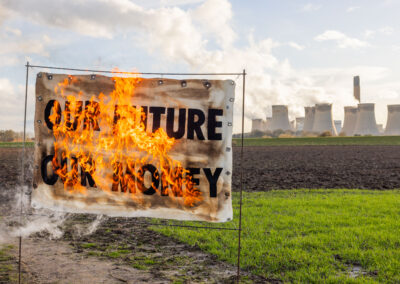 Burning banner with Our Future Our Money written on it