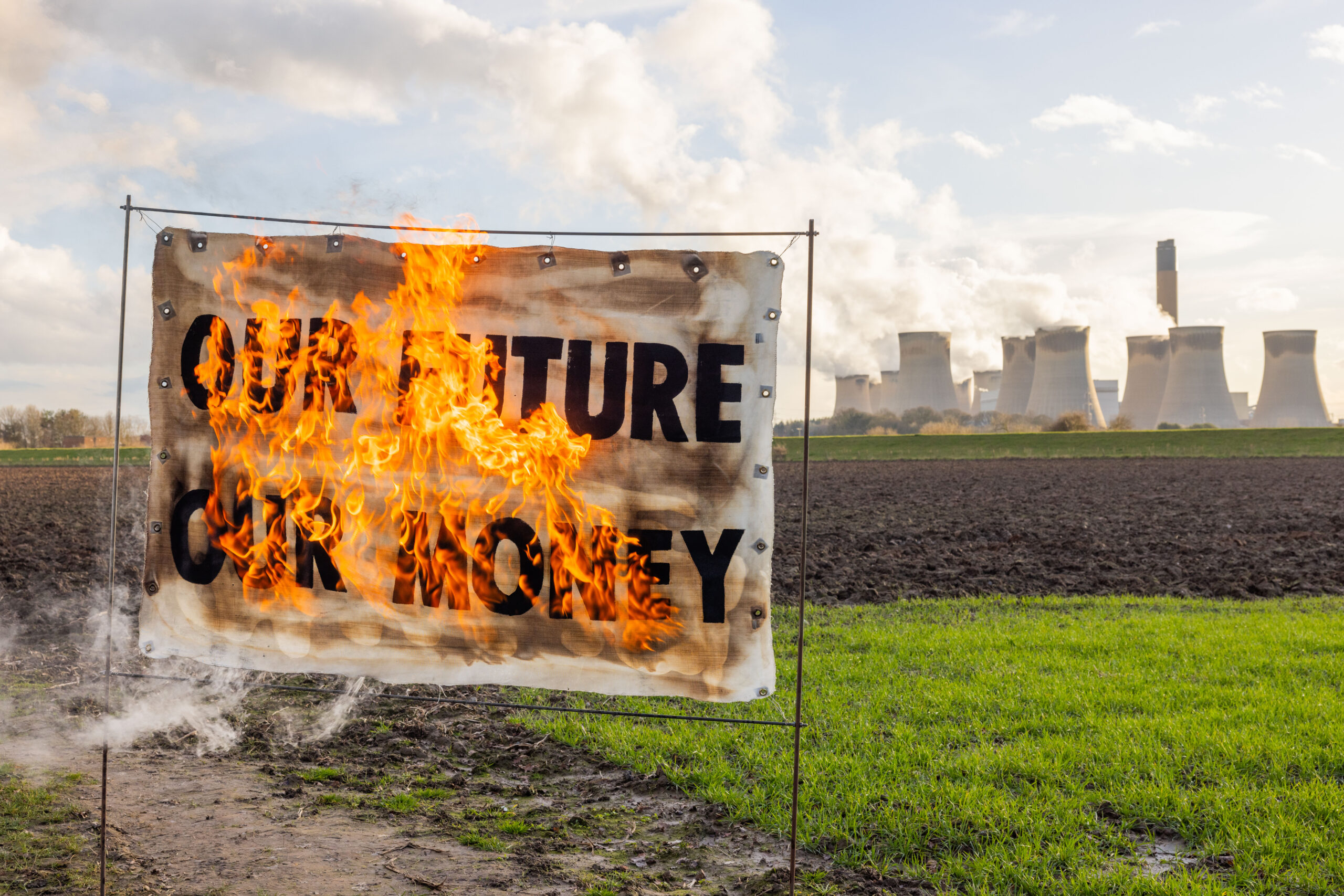 Burning banner with Our Future Our Money written on it